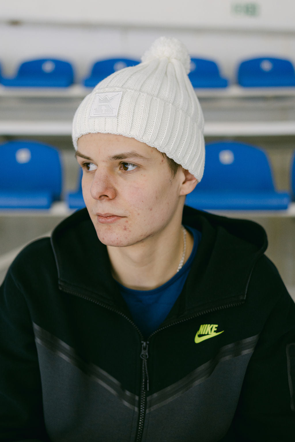 Біла шапка з помпоном і логотипом